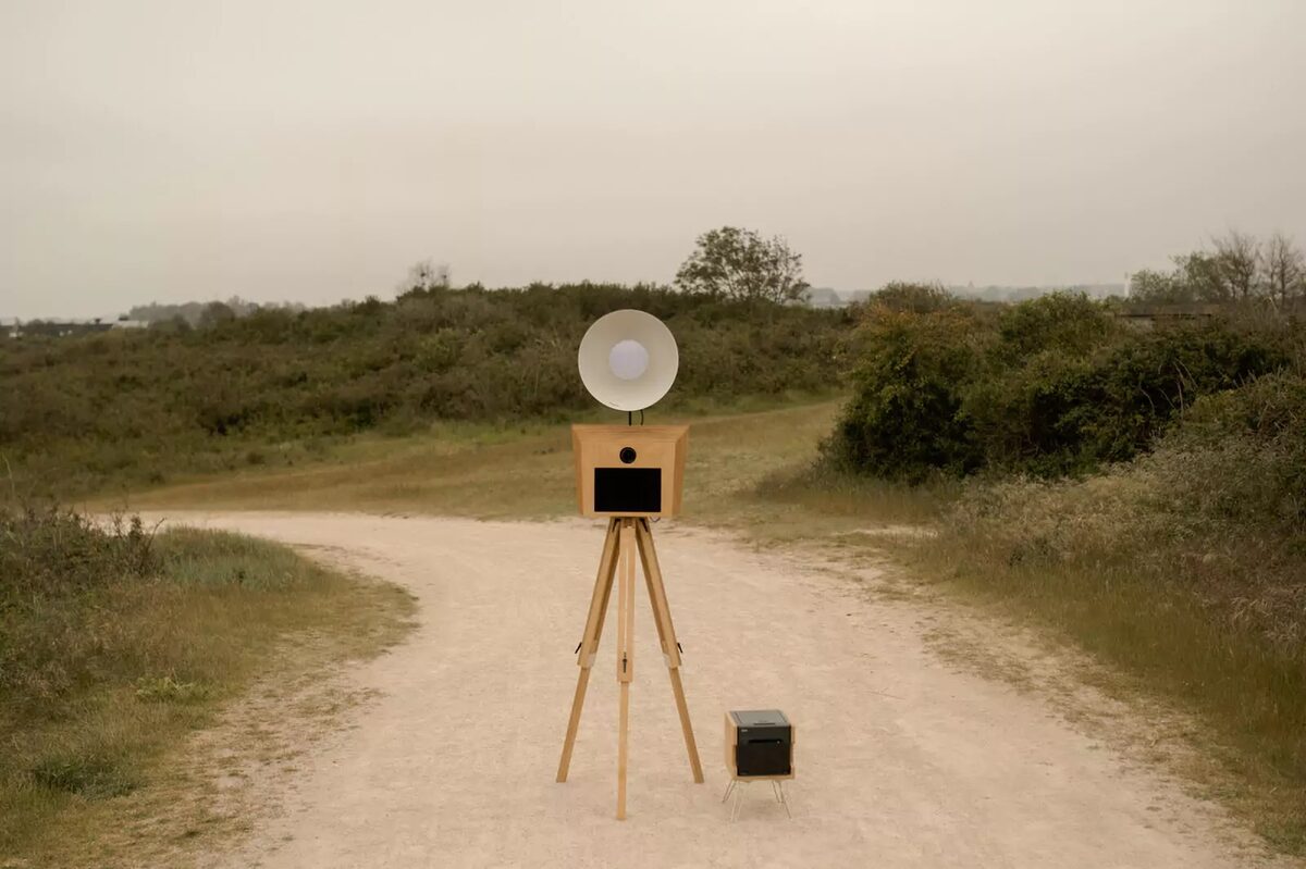 La borne photobooth Irria en pied avec sa lampe rétro et son trépied en bois
